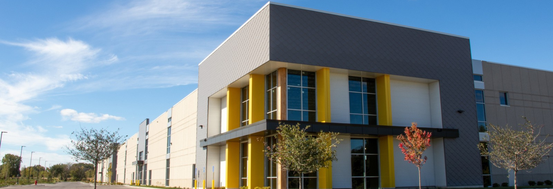 Modern commercial facility with bold architectural entry, large-scale building footprint, and integrated site access and parking.
